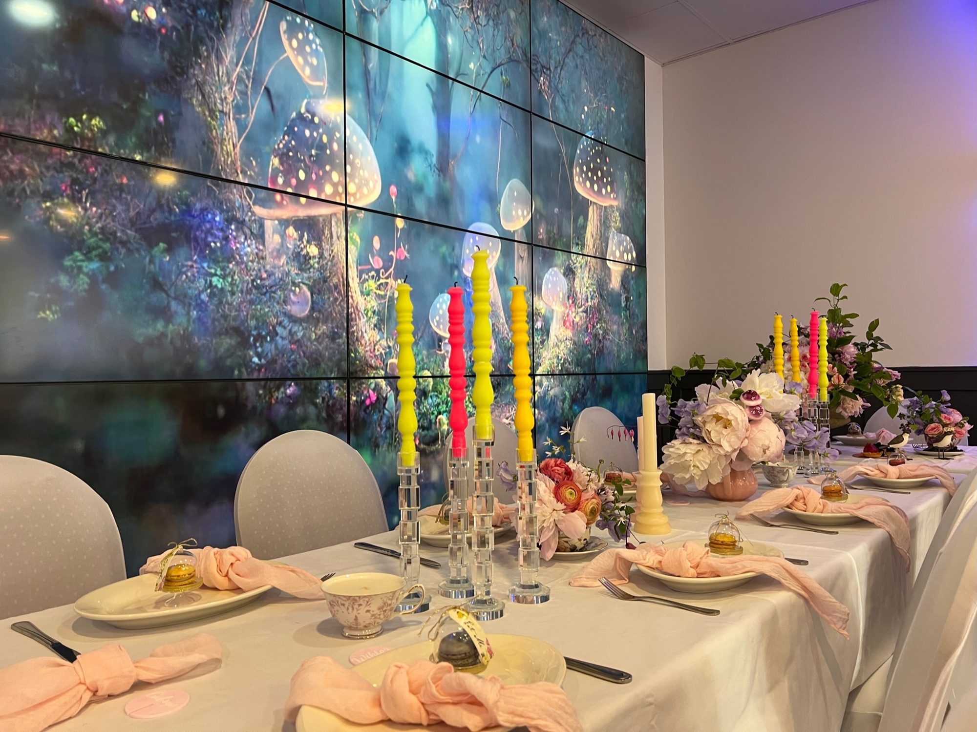 Bespoke private dinner table in front of the 150-inch video wall at The Space Next Door, Ridgewood
